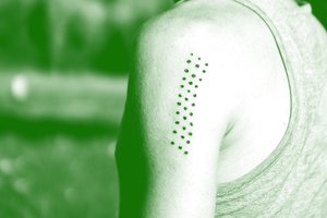 Person with aligned dots tattoo on shoulder